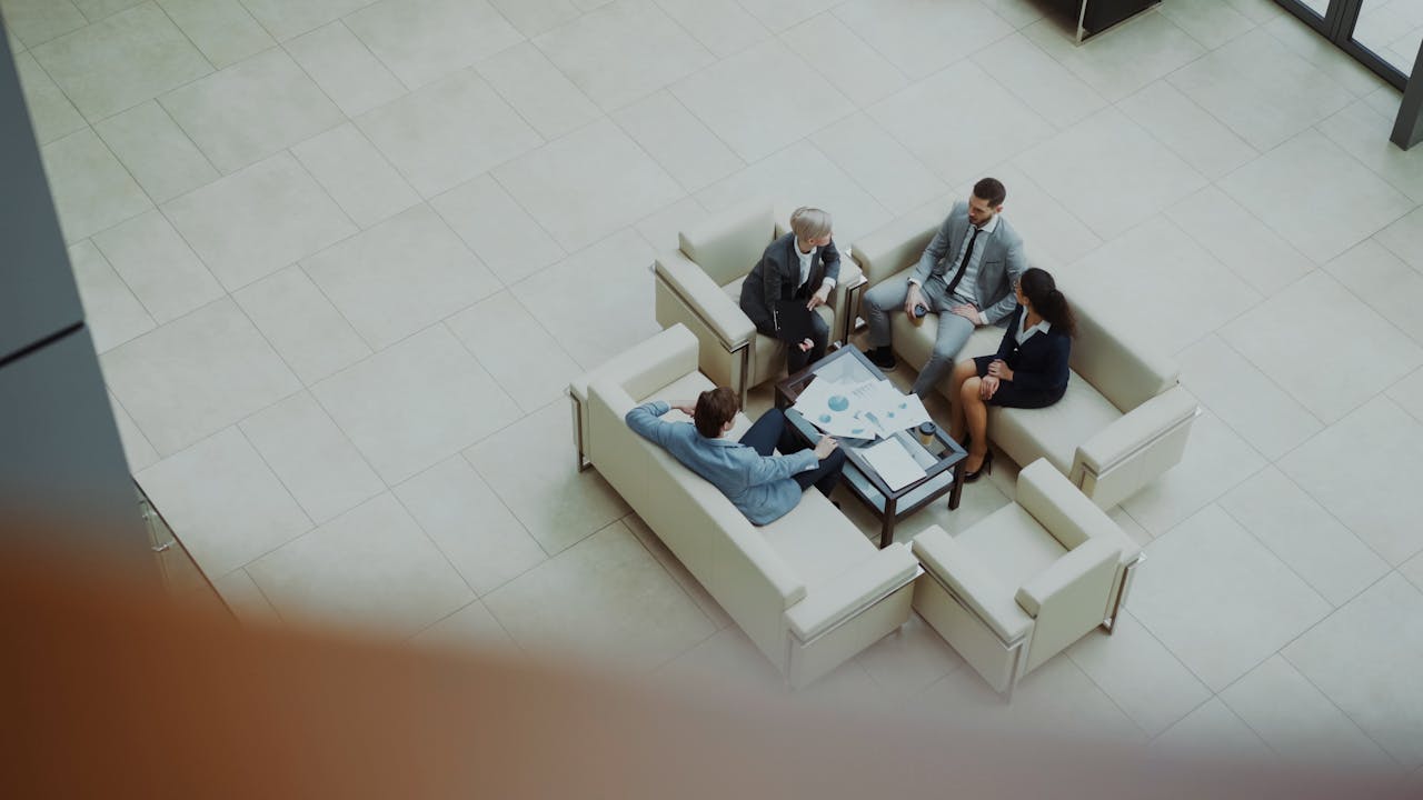 gallery-3 Business professionals in a meeting, viewed from above, in a modern office setting.