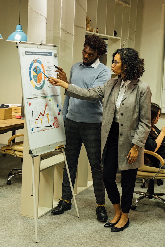 why-choose-us Colleagues engage in data analysis discussion during a team meeting in a contemporary office space.